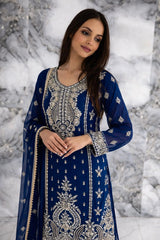 Woman wearing a blue embroidered traditional outfit against a marble background