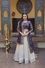 Woman in a traditional outfit standing in a decorated room with ornate walls and decor.