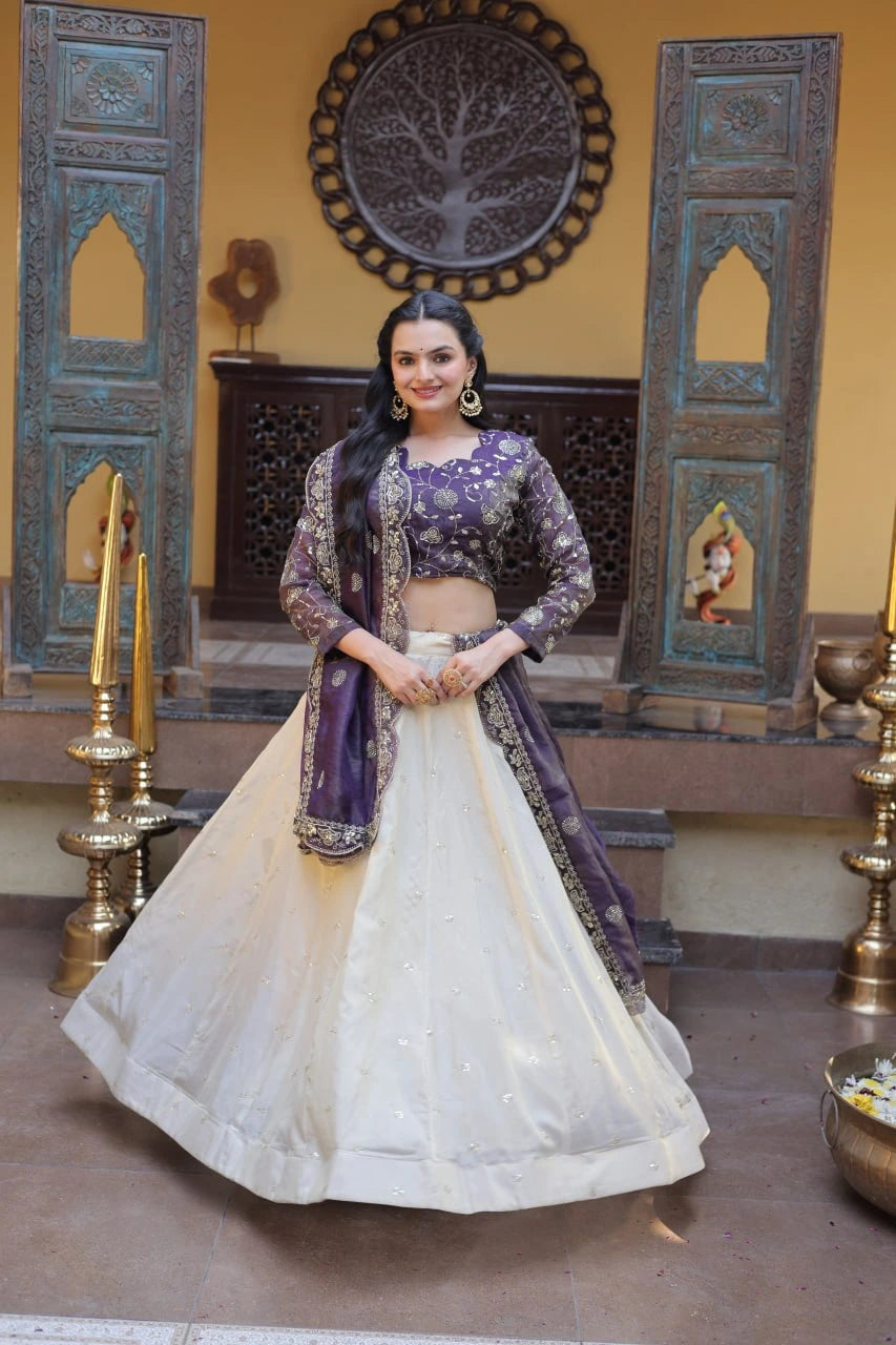 Woman in a traditional outfit standing in a decorated room with ornate walls and decor.