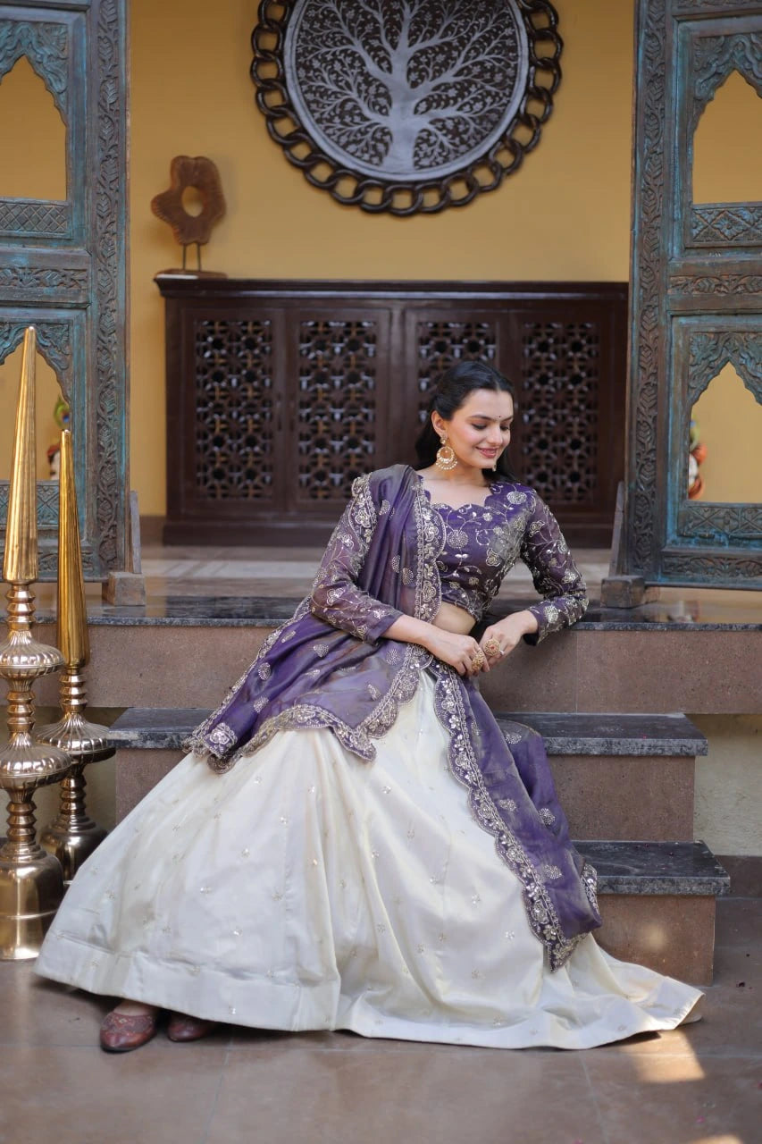 Woman in a traditional outfit sitting on steps with decorative wall and furniture in the background