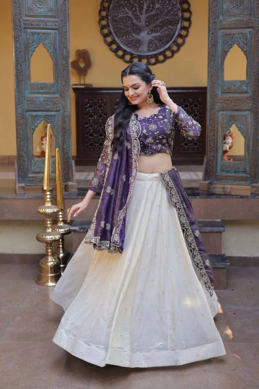 Woman in a traditional outfit with a purple top and white skirt in an ornate setting.
