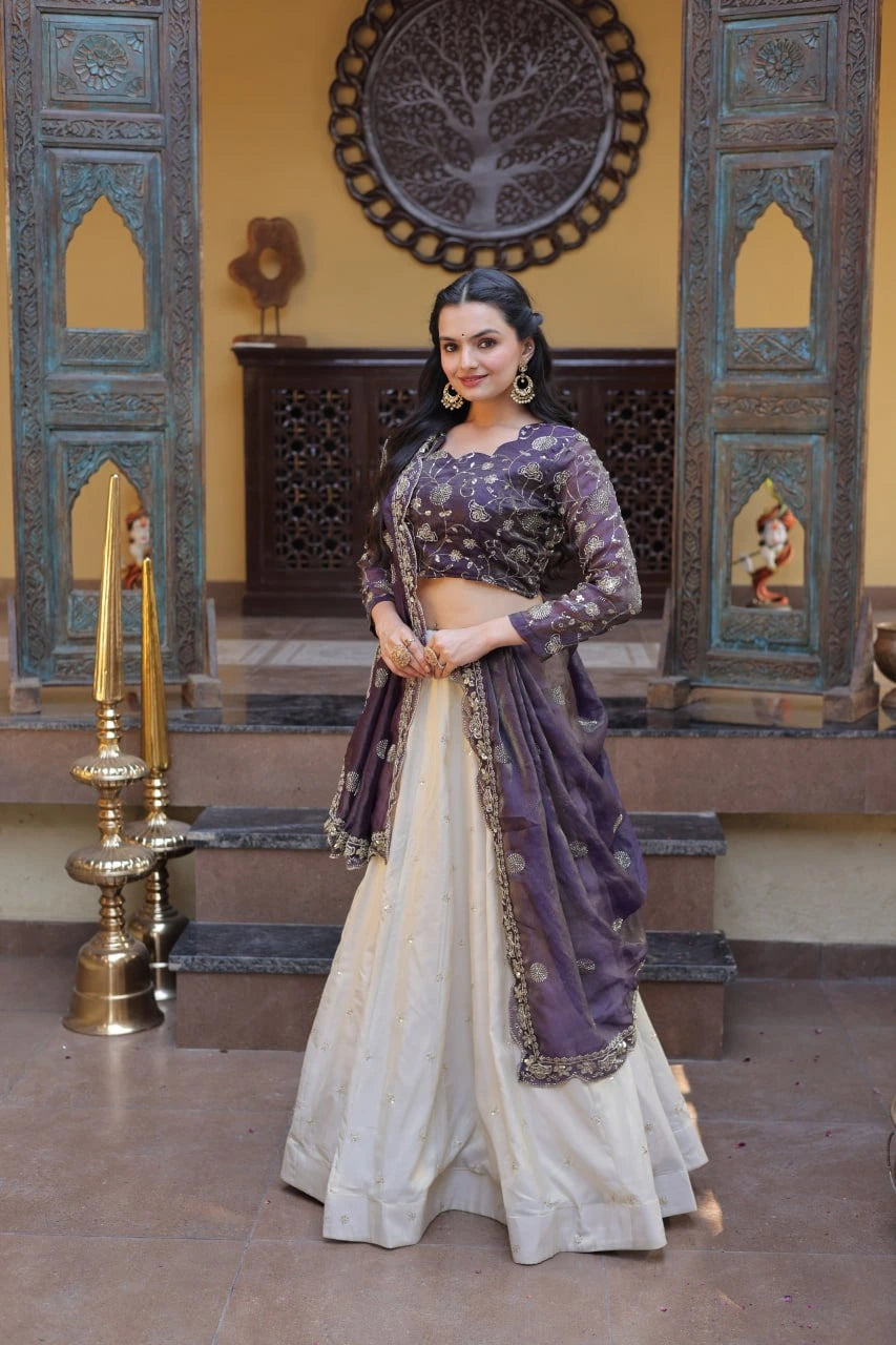 Woman in a traditional outfit standing in a decorated room with ornate wall designs.