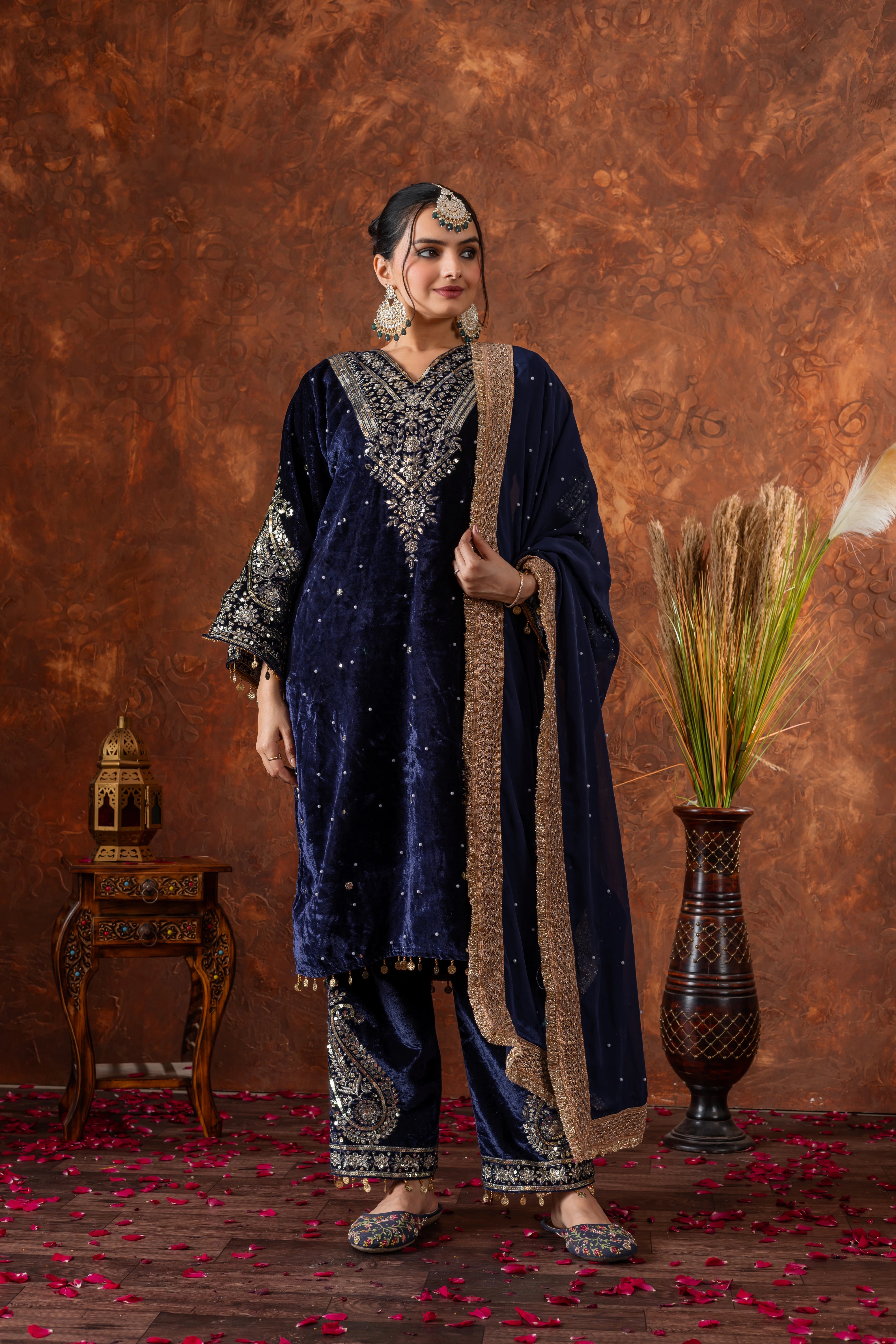Woman in traditional navy blue and gold outfit with a textured brown background