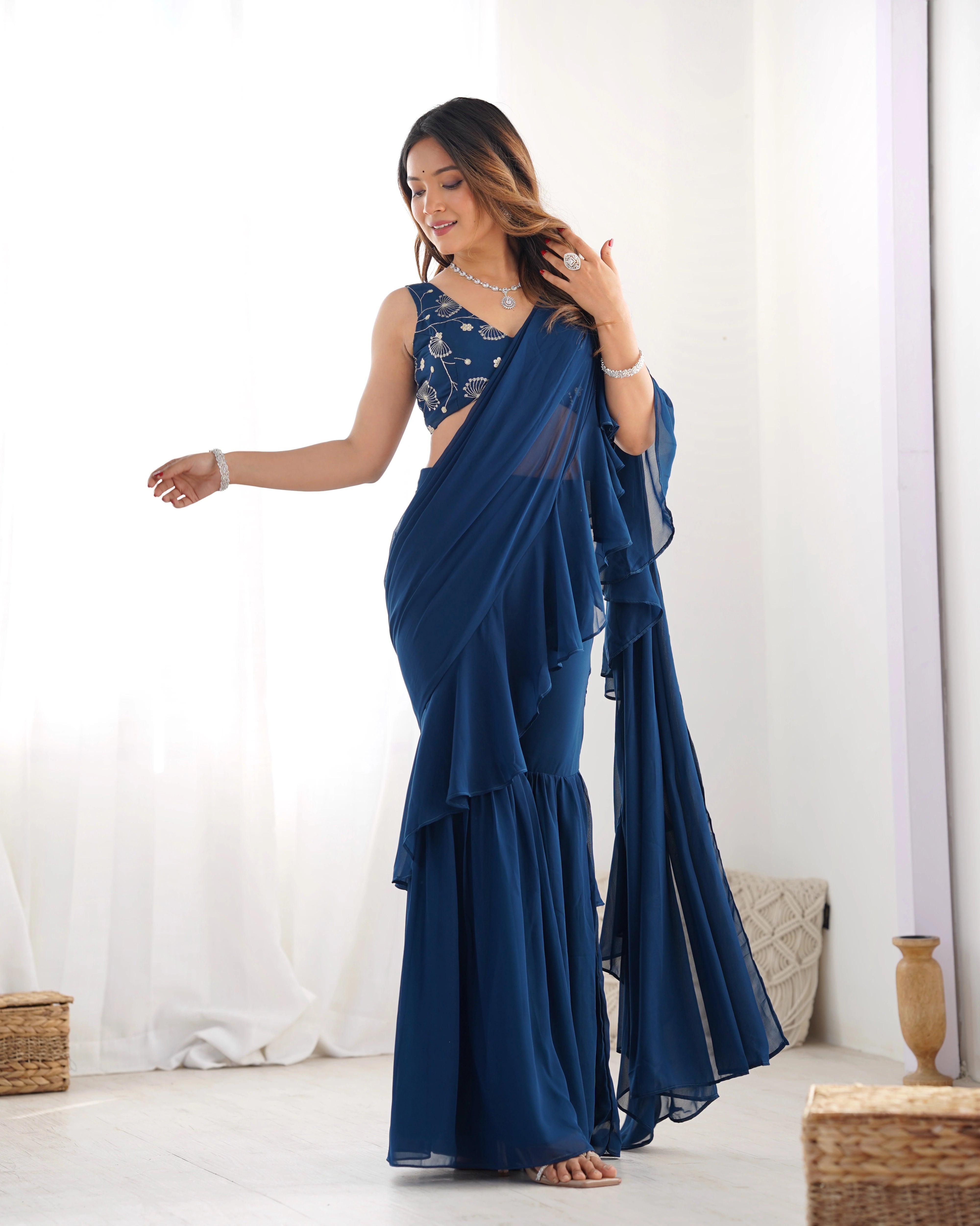 Woman wearing a blue saree with a white background