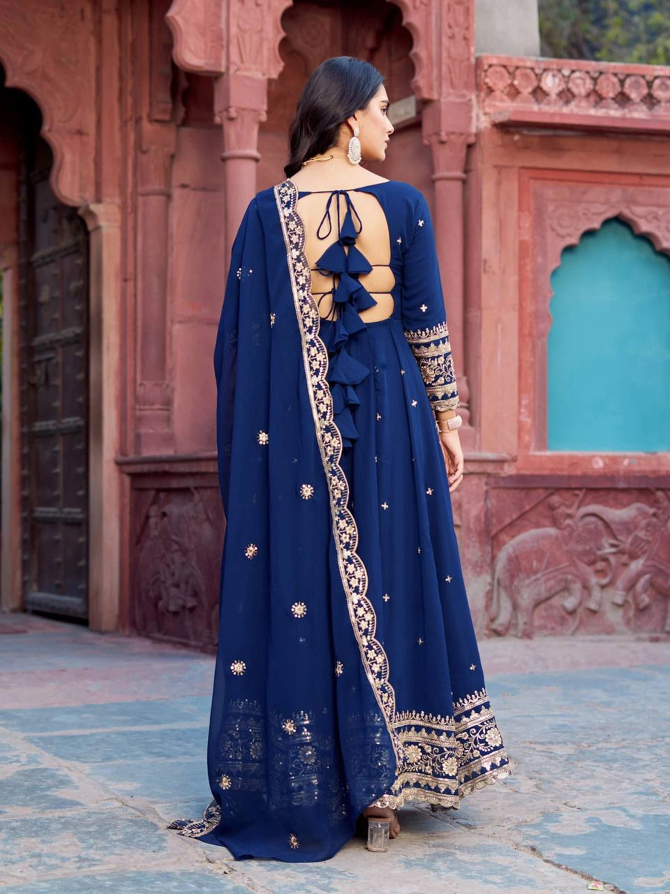 The outfit features intricate gold floral embroidery along the borders and hemline.
