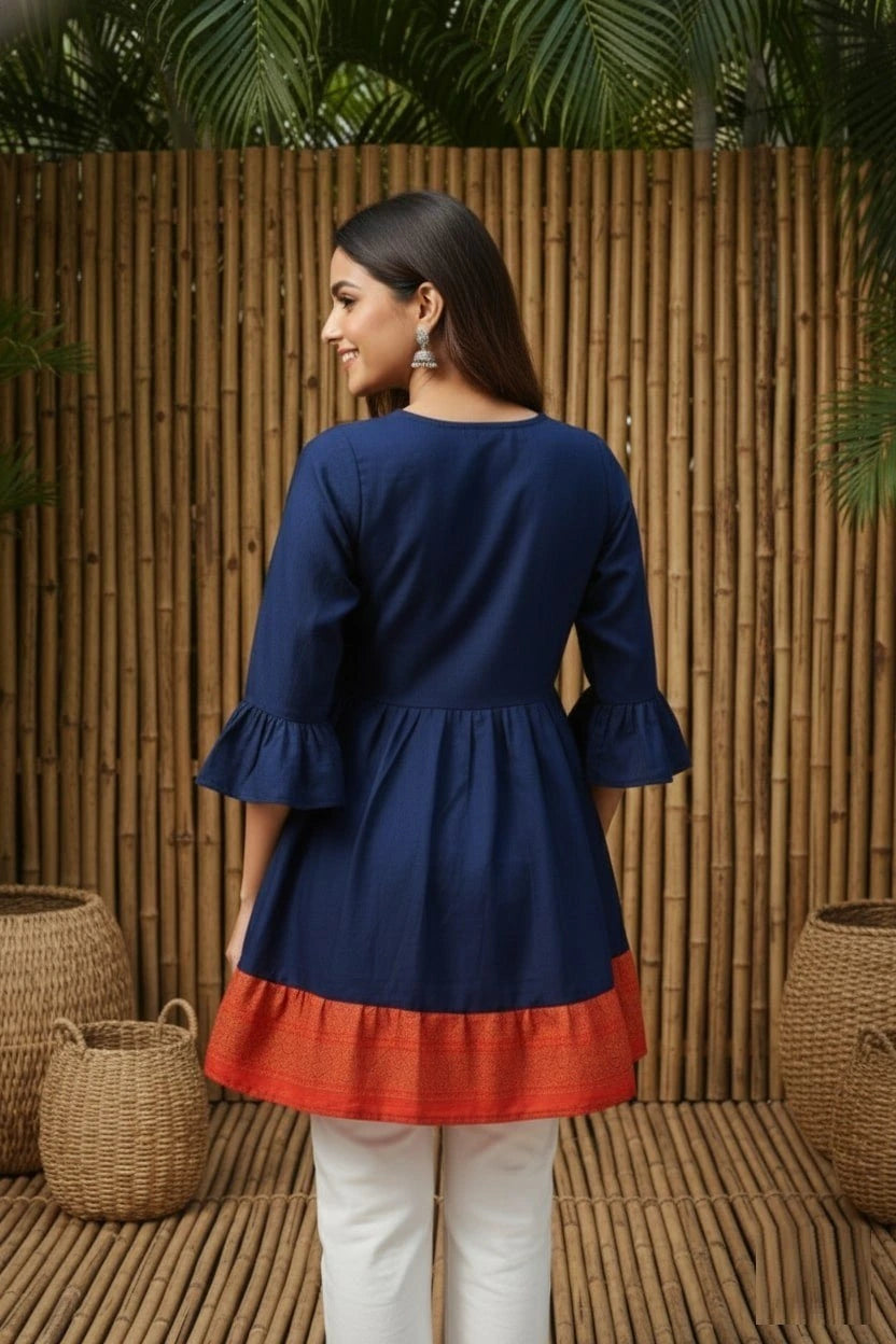 Woman wearing a blue and red dress with a bamboo wall background