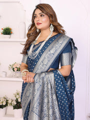 Woman wearing a blue saree with white patterns in a decorative setting.