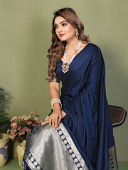 Woman wearing a navy blue saree with a green background