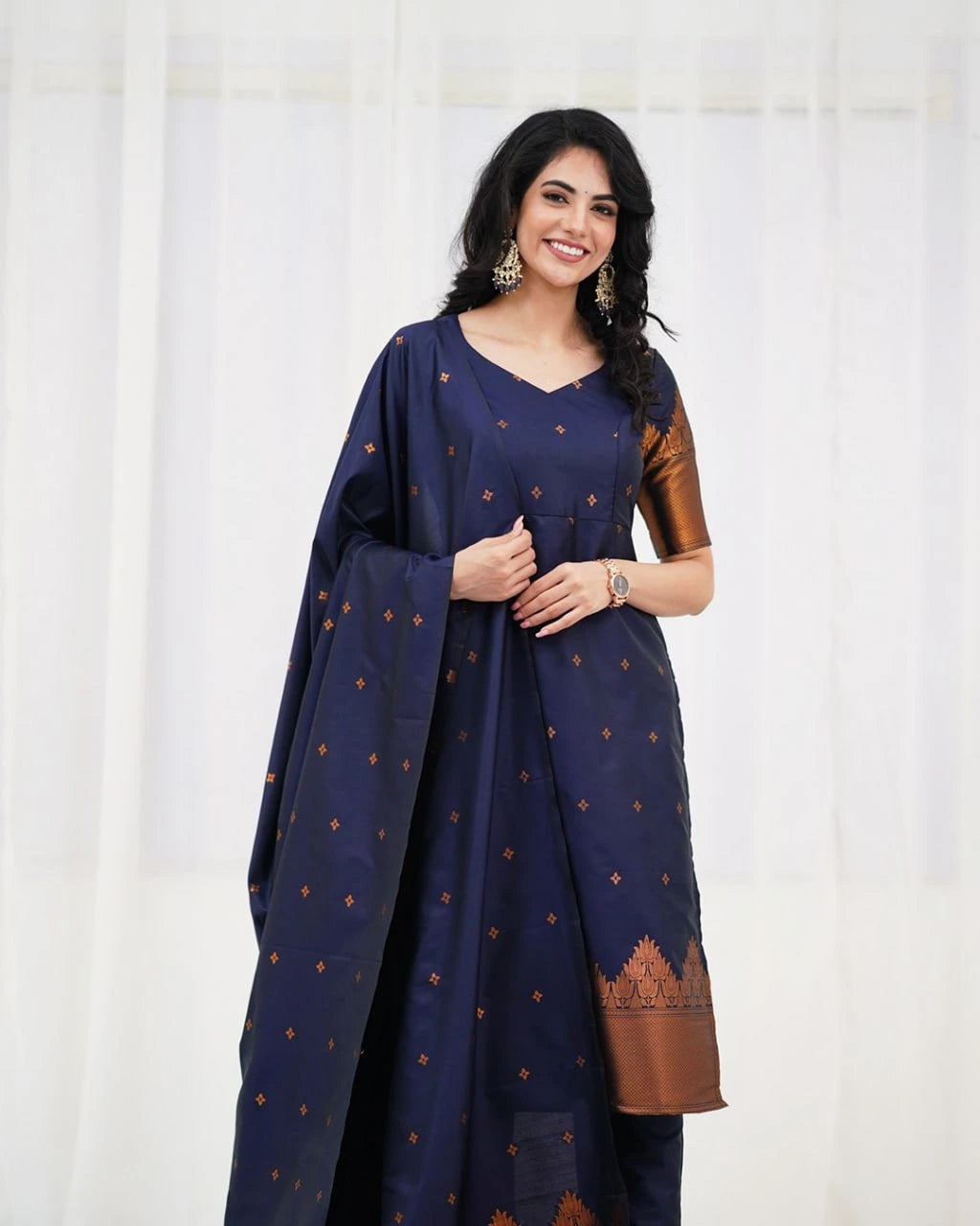 Woman wearing a navy blue traditional outfit with brown patterns on a white background