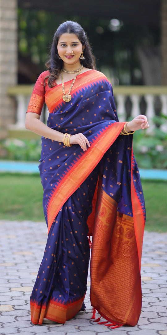 Woman wearing a blue and orange saree with a blurred outdoor background