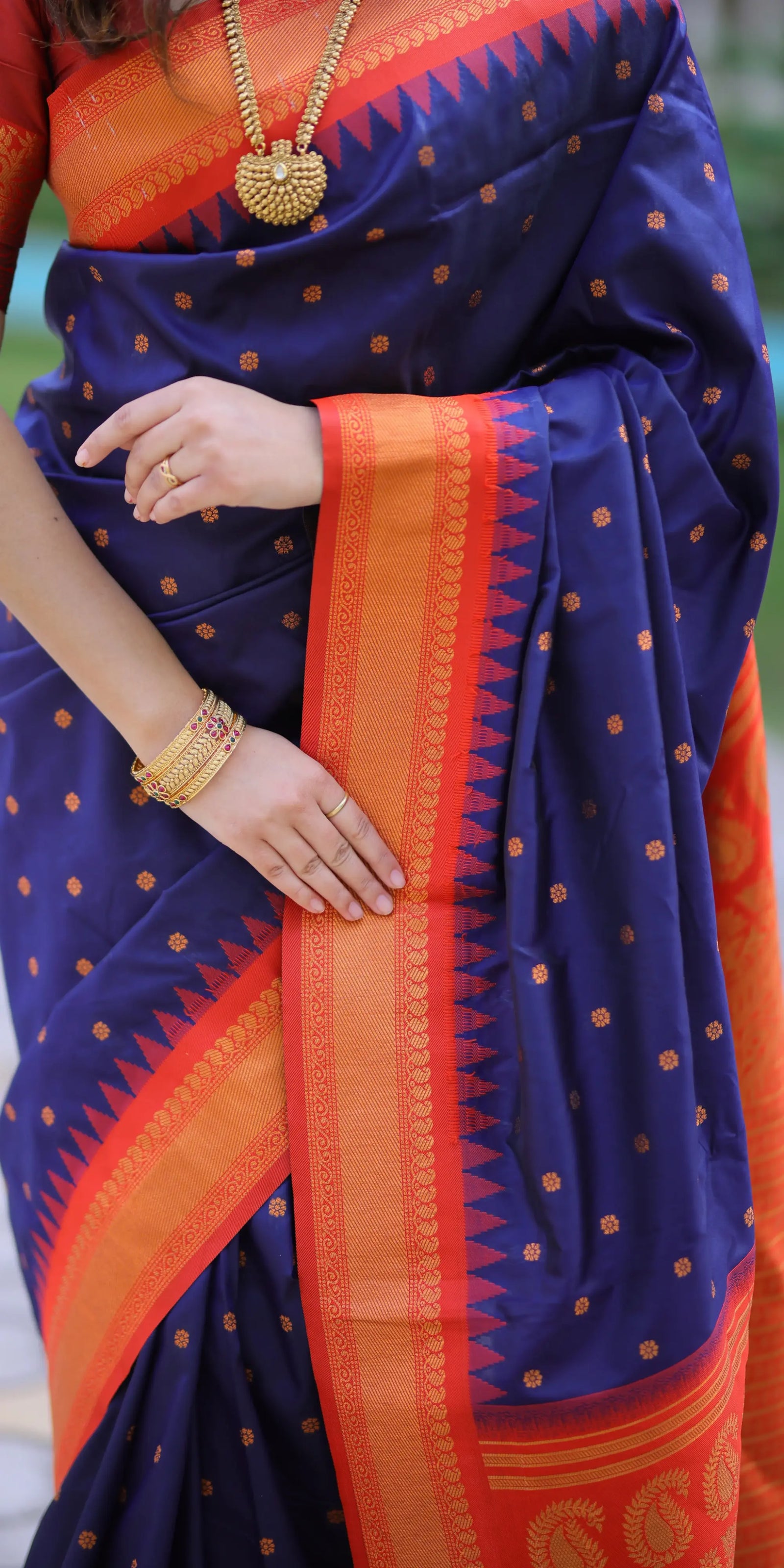 Navy blue saree with orange border and gold jewelry