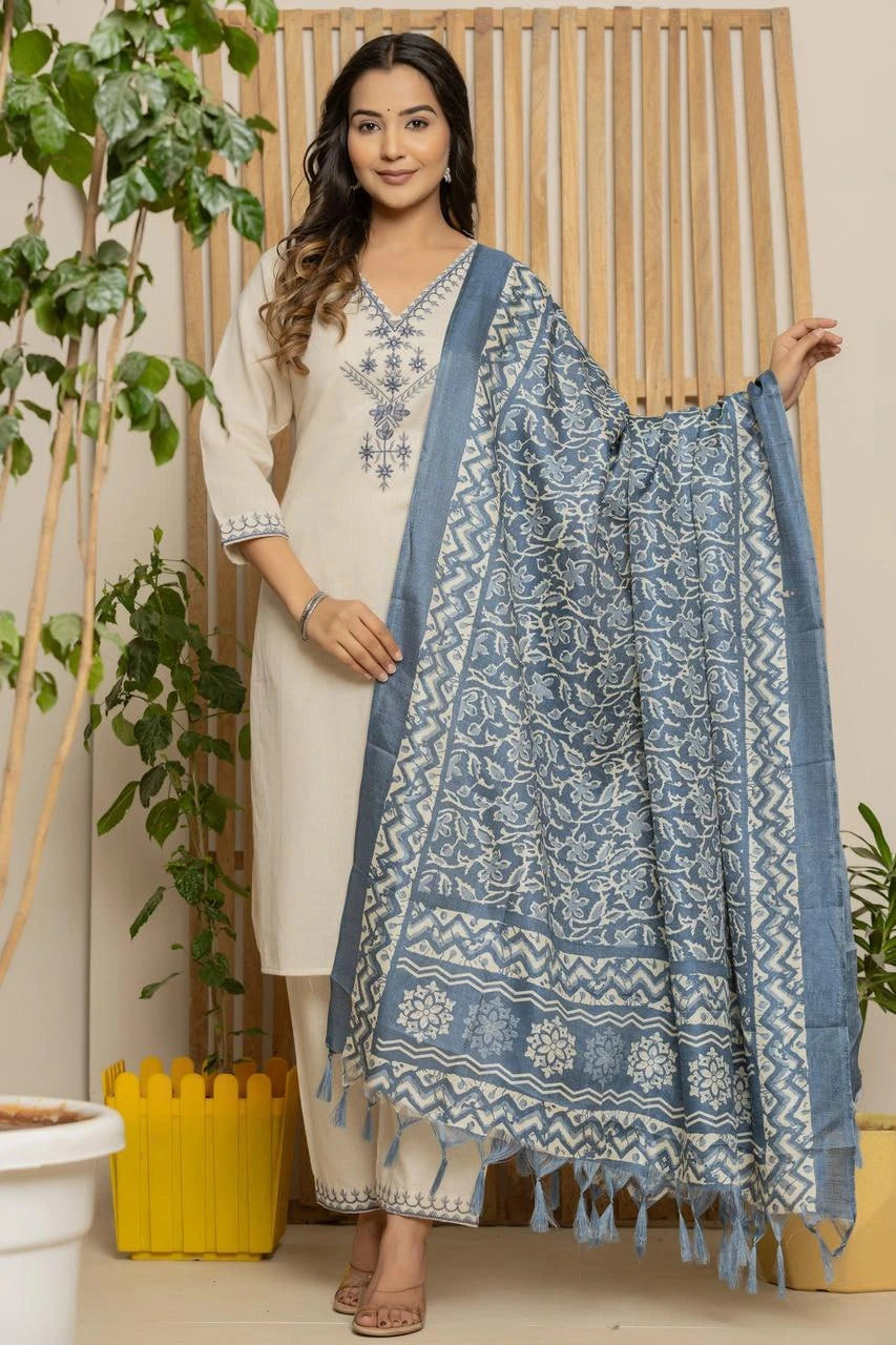 Woman holding a blue patterned dupatta with plants in the background