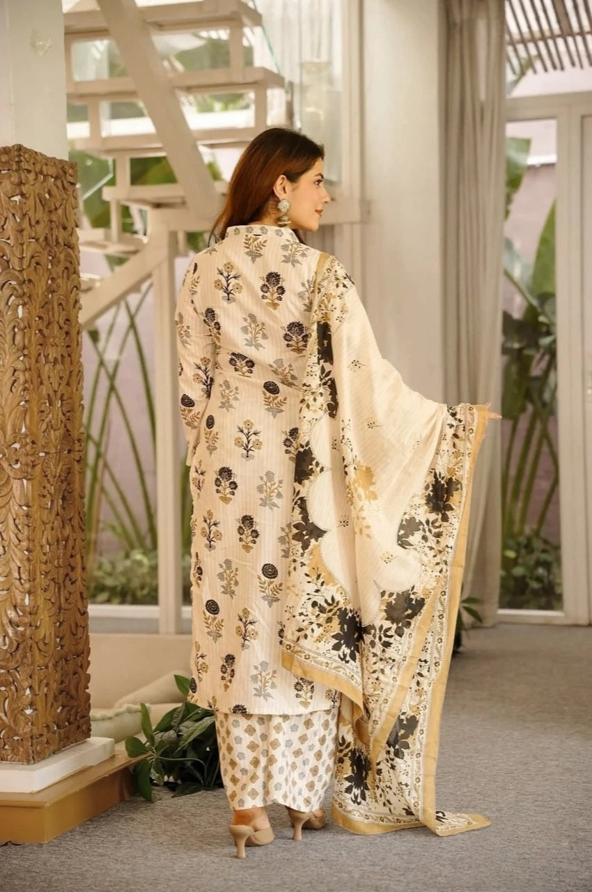 Woman in a traditional outfit standing in an indoor setting with decorative elements.