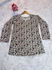 Floral patterned dress on a hanger against a textured white background