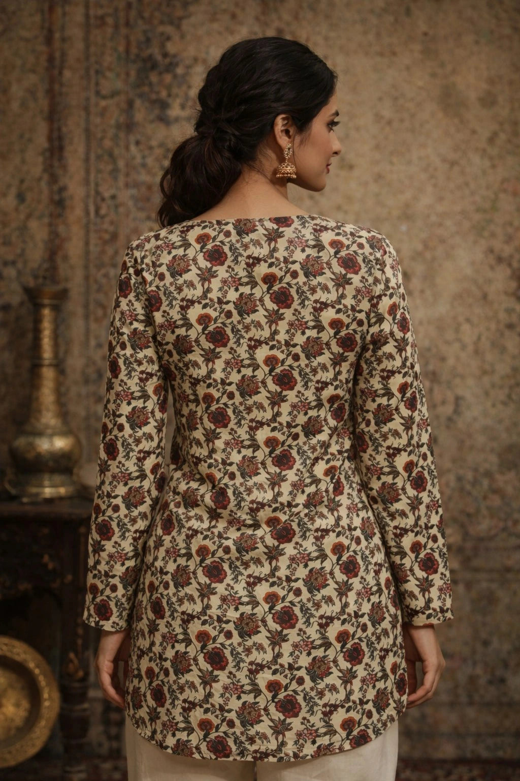 Woman wearing a floral patterned top in a warm-toned setting