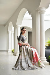 Woman in a floral saree sitting in a classical architectural setting