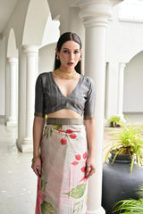 Woman in a traditional outfit with a floral skirt standing in a white architectural setting.