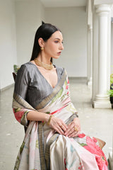 Woman in a floral saree sitting in an elegant indoor setting