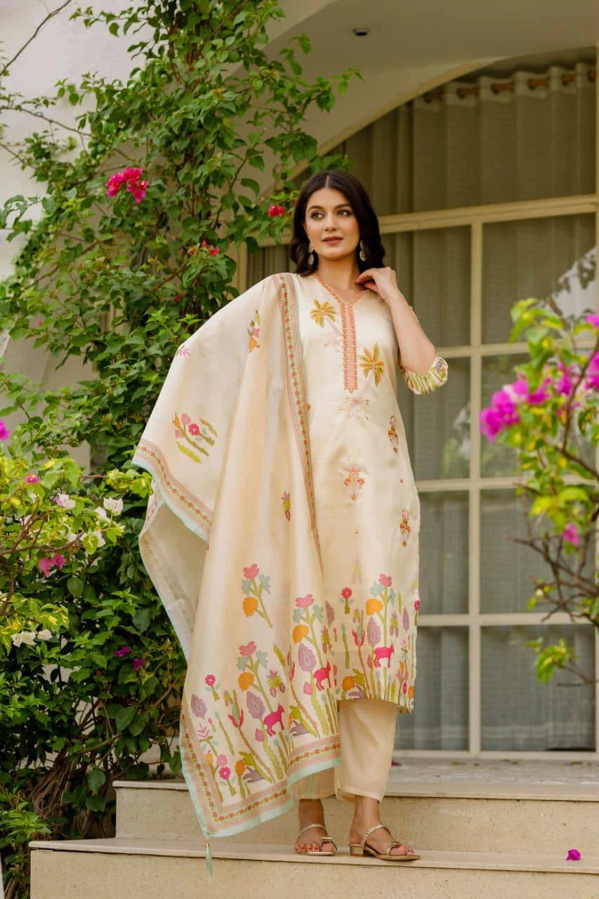Woman in a traditional outfit with floral patterns standing outdoors.