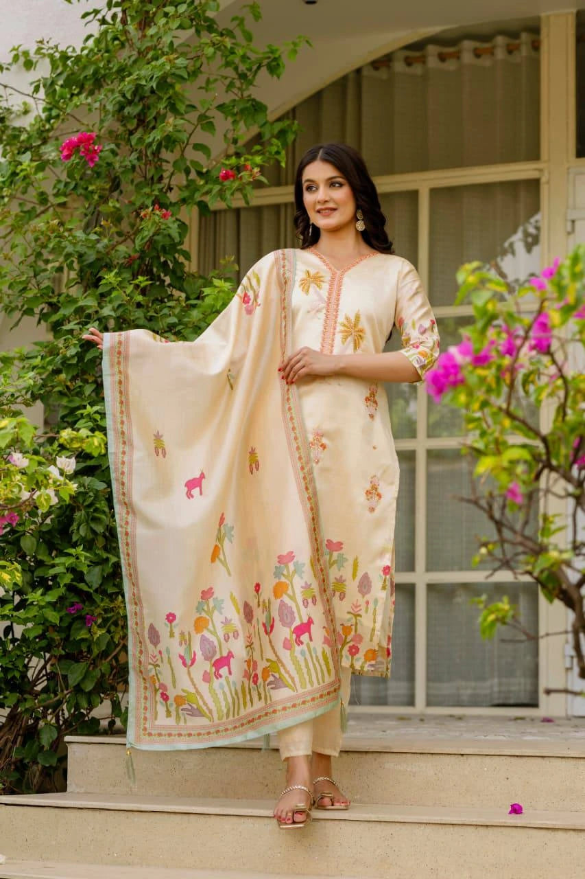 Woman in a traditional outfit standing outdoors with greenery and a building in the background