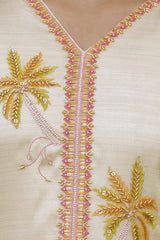 Close-up of embroidered fabric with palm tree designs and beadwork on a beige background