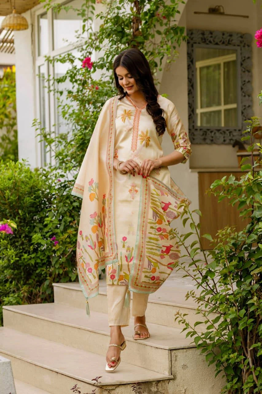 Woman in a traditional outfit with floral patterns standing outdoors.
