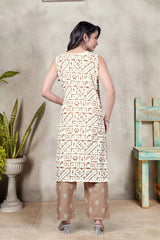 Woman wearing a patterned kurta with palazzo pants standing against a textured wall.