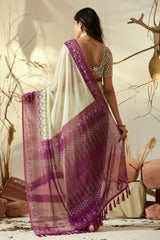 Woman wearing a white and purple saree with a natural setting