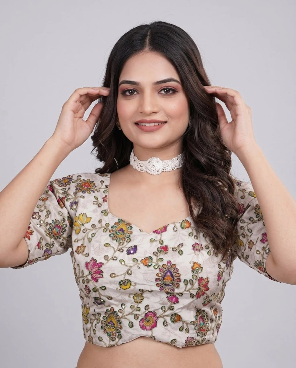 Woman wearing a floral blouse against a plain background