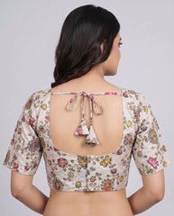 Woman wearing a floral blouse with a backless design on a plain background