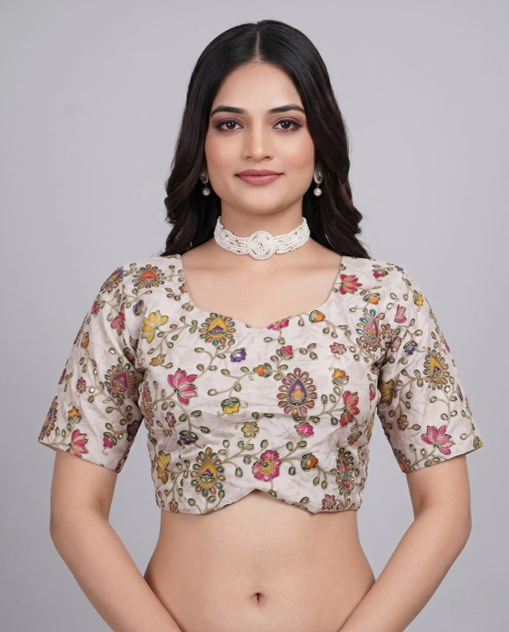 Woman wearing a floral blouse against a gray background