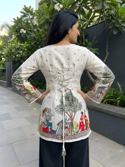 Woman wearing a traditional outfit with intricate patterns outdoors.