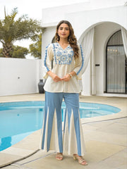 Woman in a white and blue outfit standing by a pool