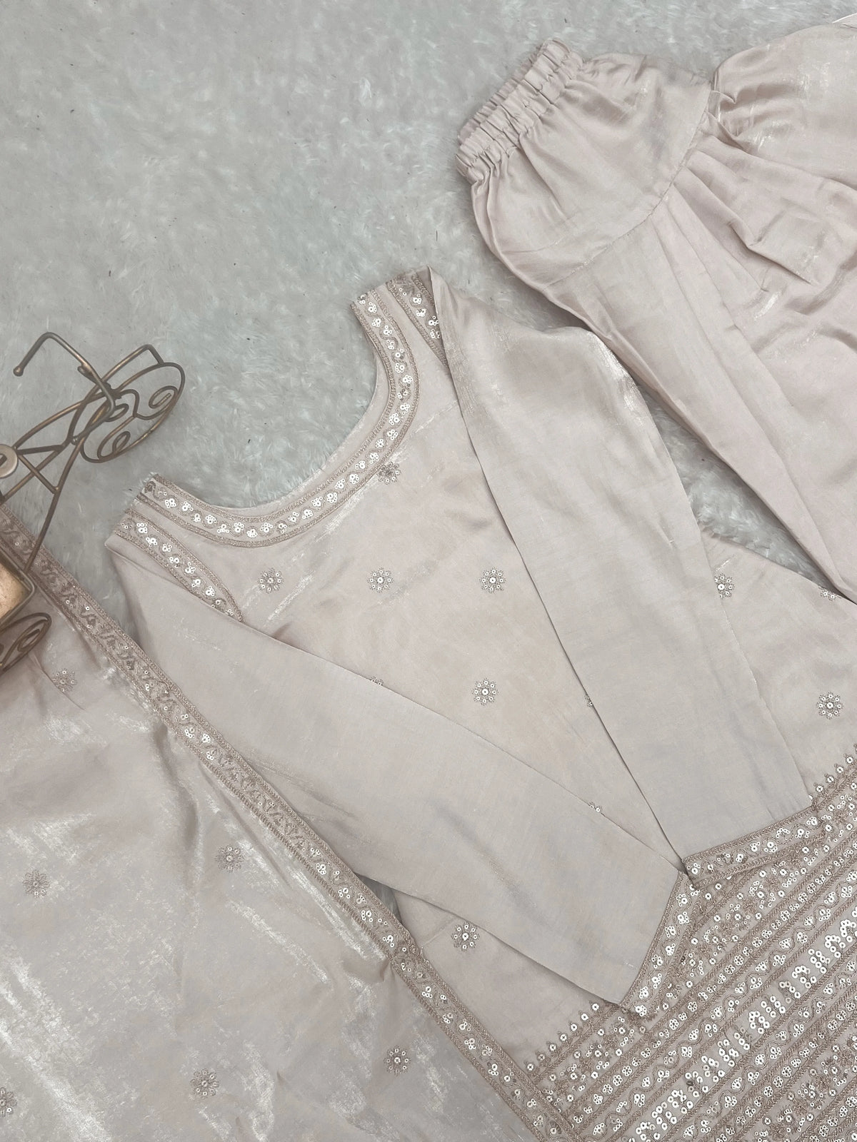 Light gray embroidered garment on a textured surface