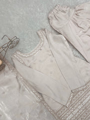 Light gray embroidered garment on a textured surface