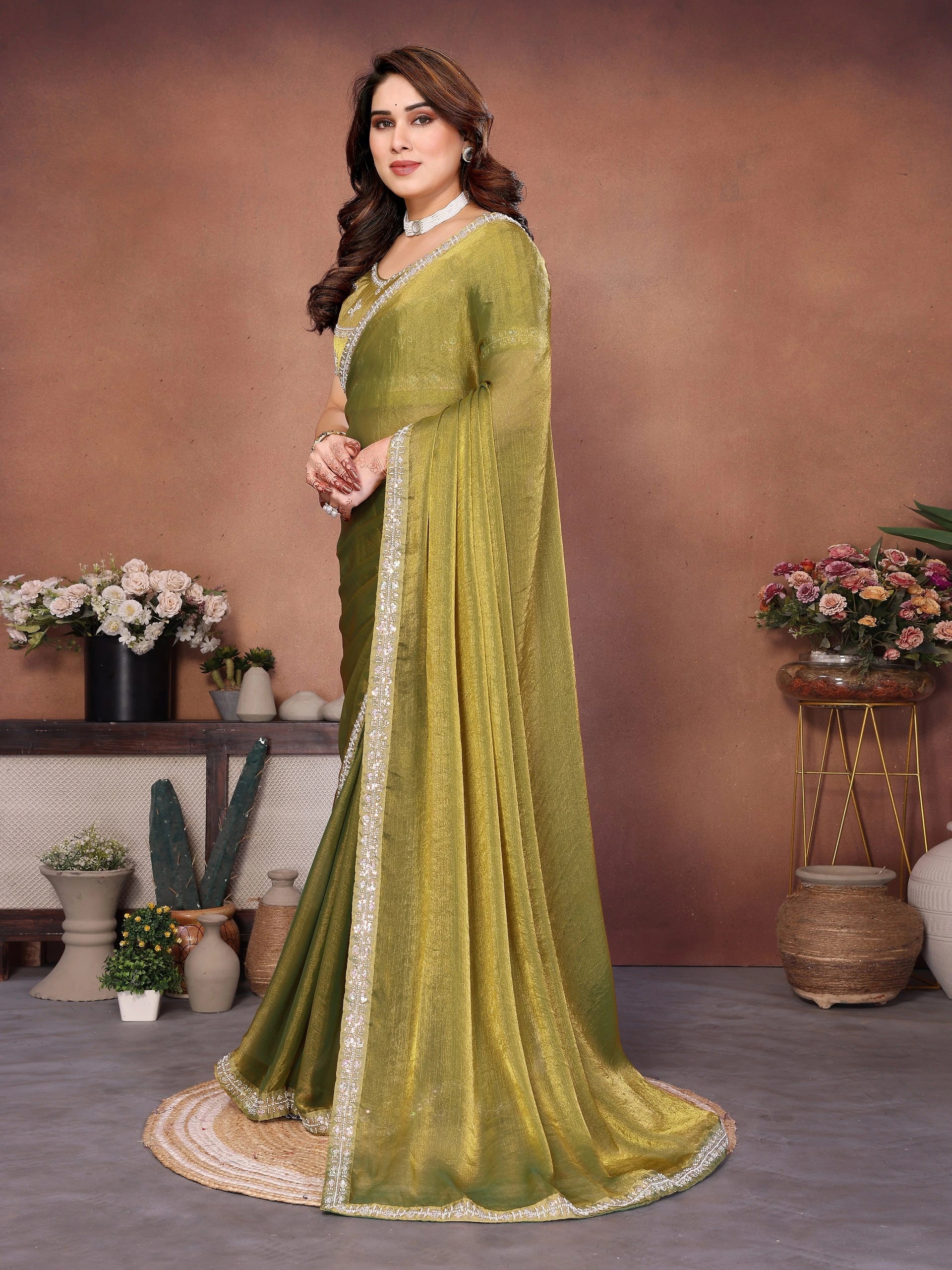 Woman wearing a green saree with a brown background