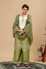 Woman wearing a green traditional outfit with a beige background