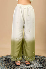 White and green gradient pants with button details on a beige background