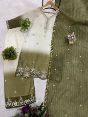 Green and white embroidered traditional outfit on a hanger with decorative elements.