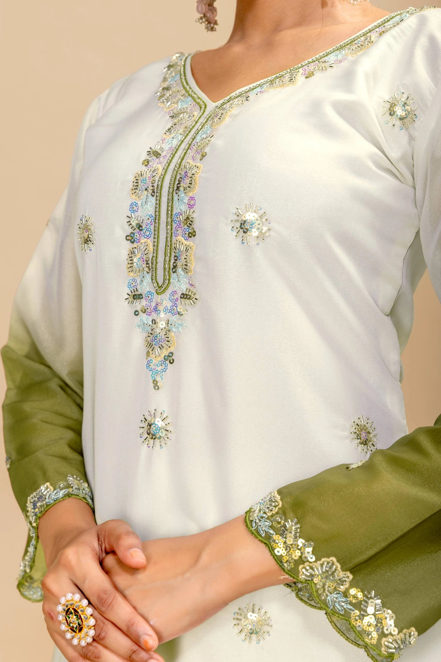 White and green embroidered traditional outfit with floral patterns