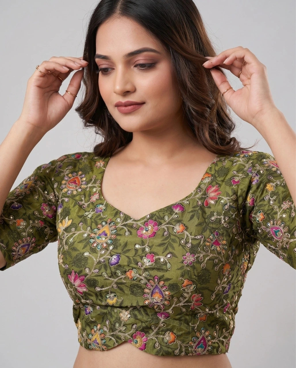 Woman wearing a green floral blouse against a plain background