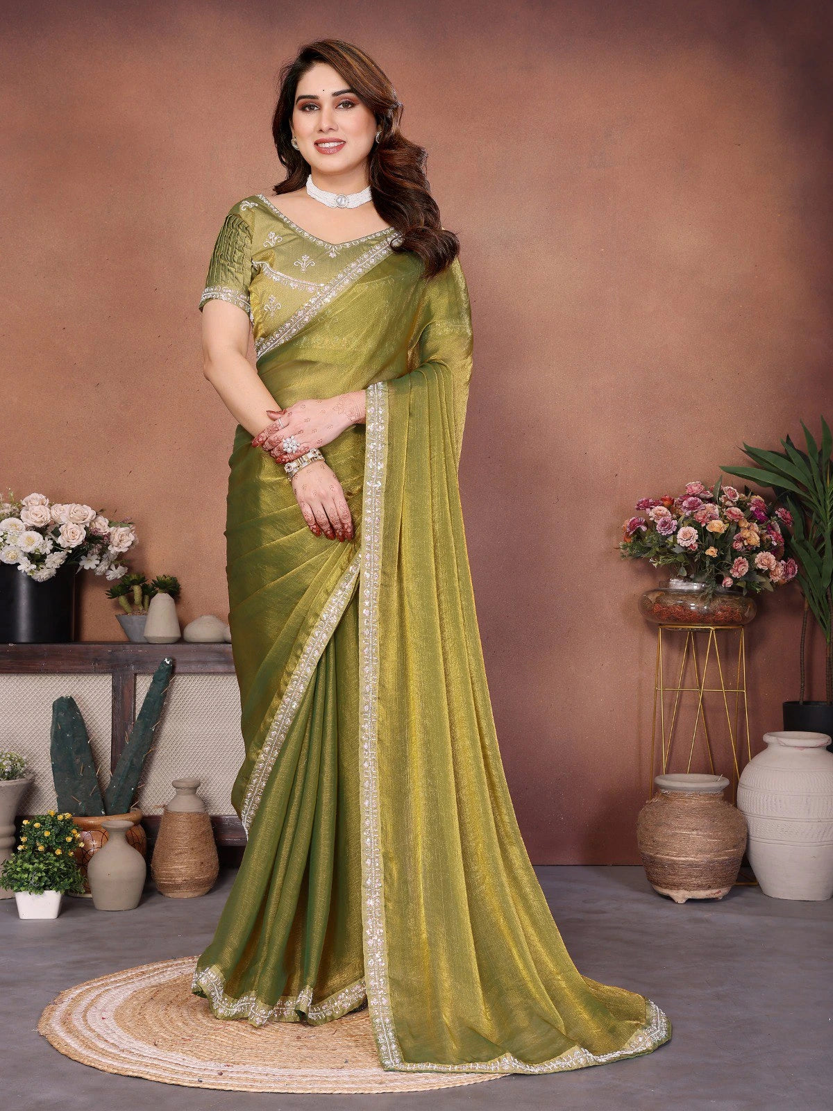 Woman wearing a green saree with a brown background