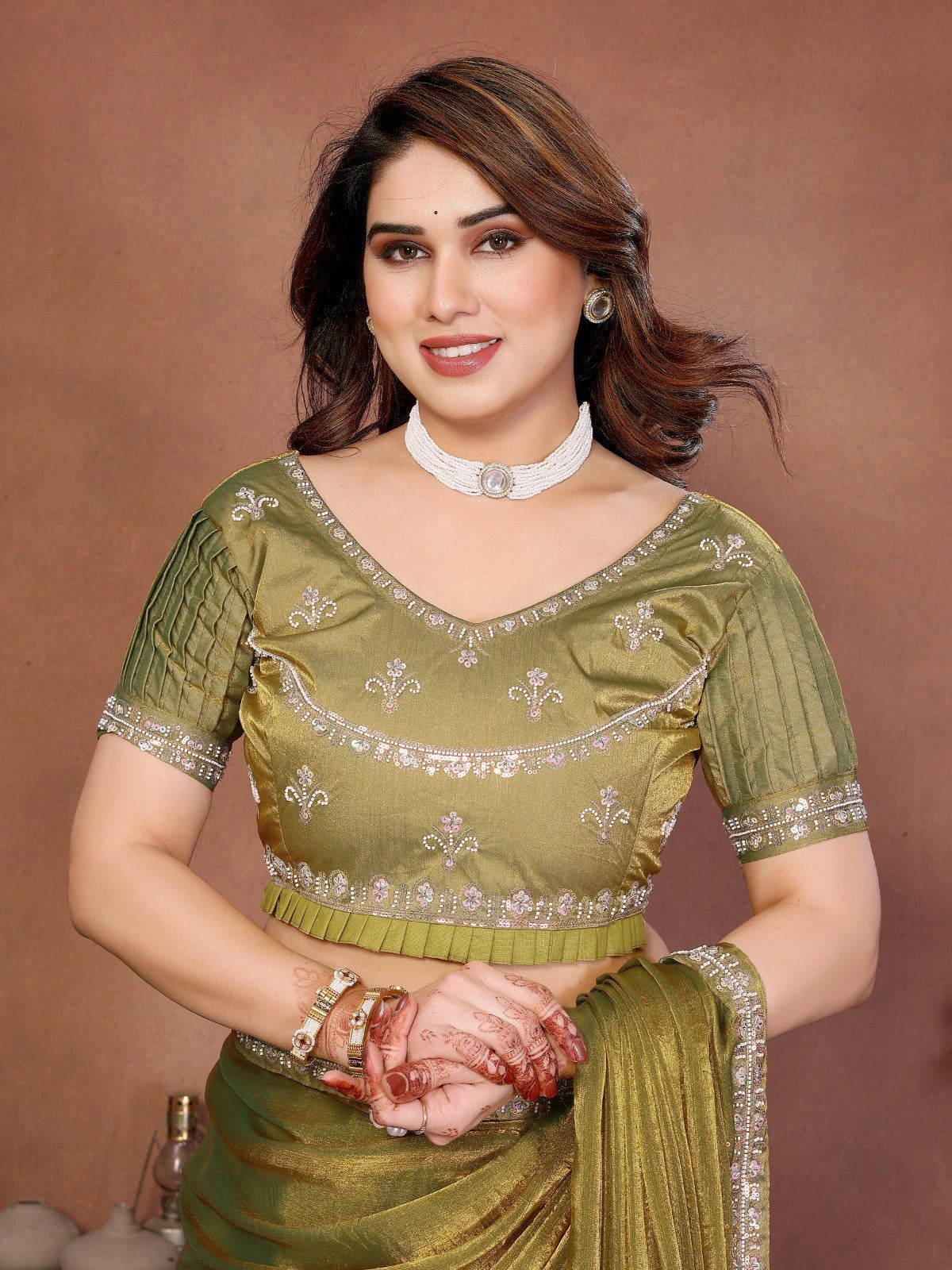 Woman wearing a green traditional outfit with a brown background