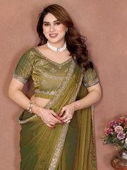 Woman in a green saree with floral decorations in the background