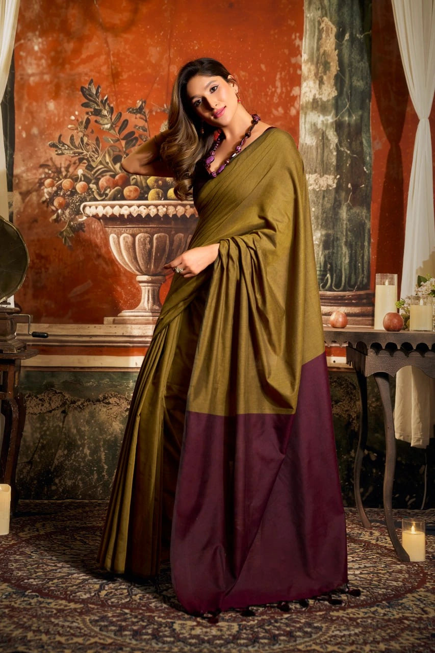 Woman in a green and purple traditional outfit standing in an ornate room with classical painting.