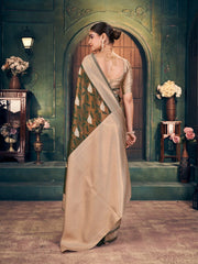 Woman in a traditional saree standing in an ornate room with decorative elements.