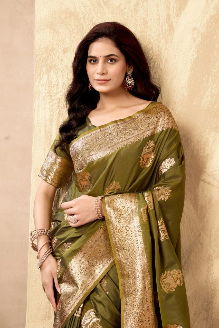 Woman wearing a green saree with gold patterns against a beige background