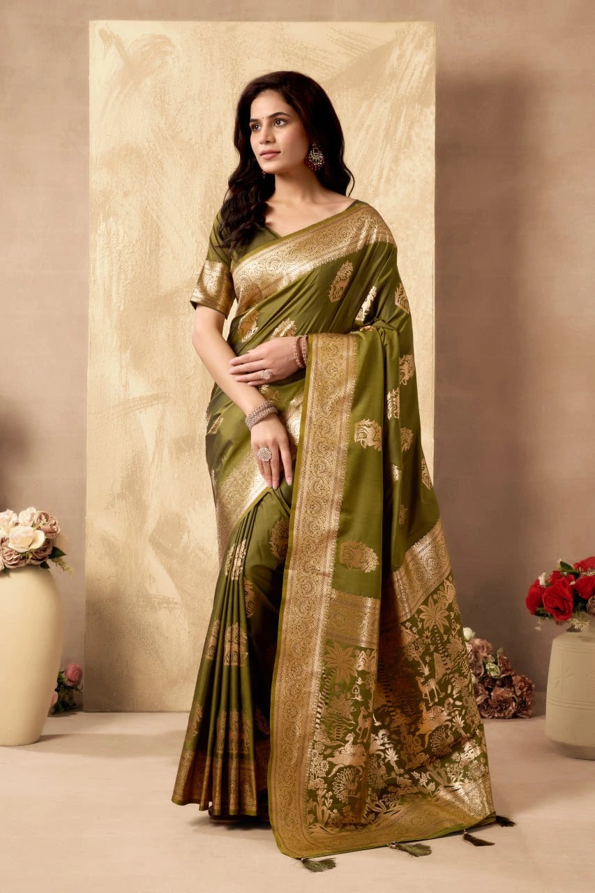Woman wearing a green saree with gold patterns against a neutral background