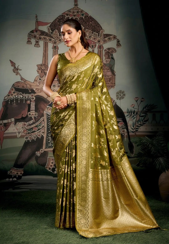 Woman in a green saree standing in front of an elephant sculpture.