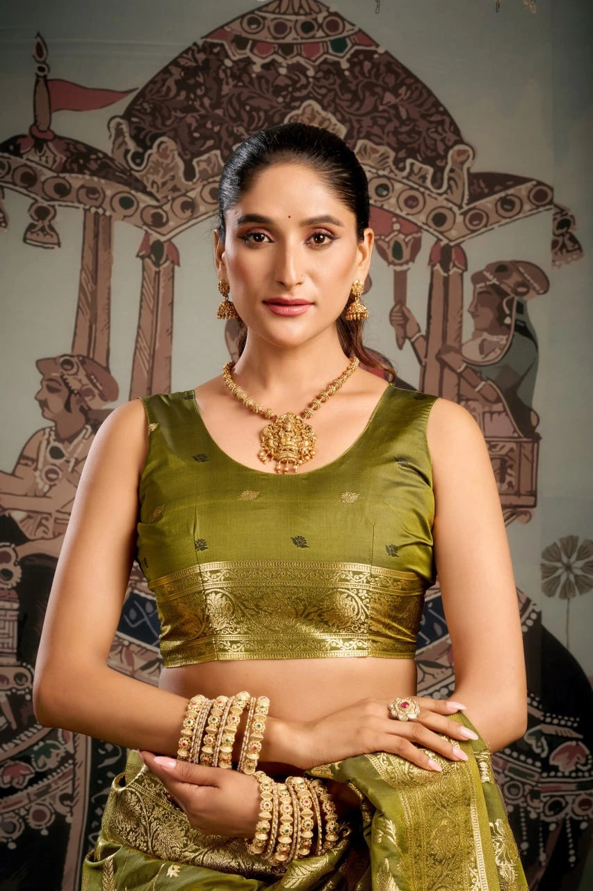 Woman in traditional green attire with jewelry against a decorative background